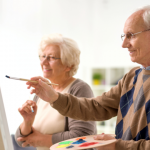 Older man and woman paint together